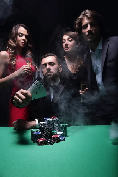 Ein glückliches Unternehmen feiert einen Sieg im Poker mit Champagner. — Stockfoto