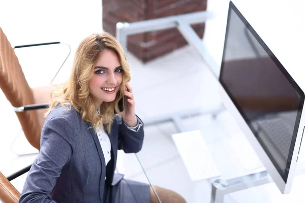 Exitosa joven mujer de negocios sentada en un escritorio —  Fotos de Stock