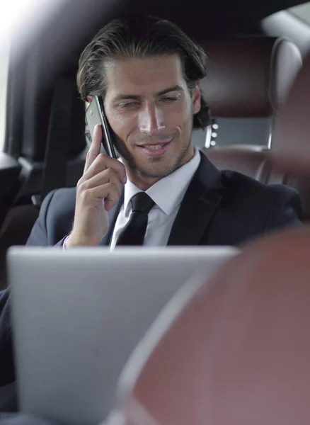 Bello uomo d'affari che utilizza il telefono cellulare in auto . — Foto Stock