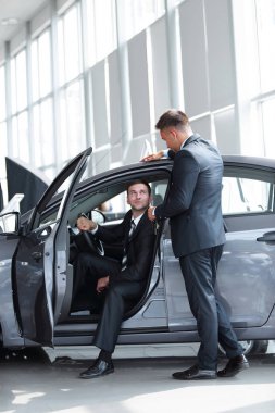 işadamı yöneticisinden yeni bir arabanın direksiyonuna oturan anahtarlarını alır..