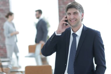 Kendine güvenen iş adamı telefonda konuşuyor..