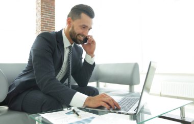 Smartphone üzerinde konuşmak ve metin dizüstü bilgisayarda yazarak işadamı