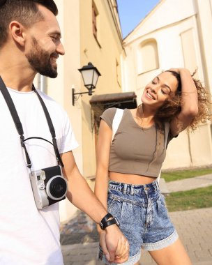 Bir çift şehrin sokaklarında yürüyor ve eğleniyor.