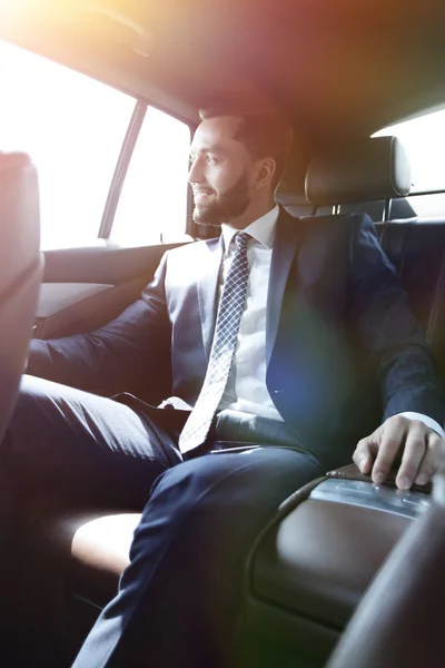 Empresário sentado no banco de trás de um carro — Fotografia de Stock