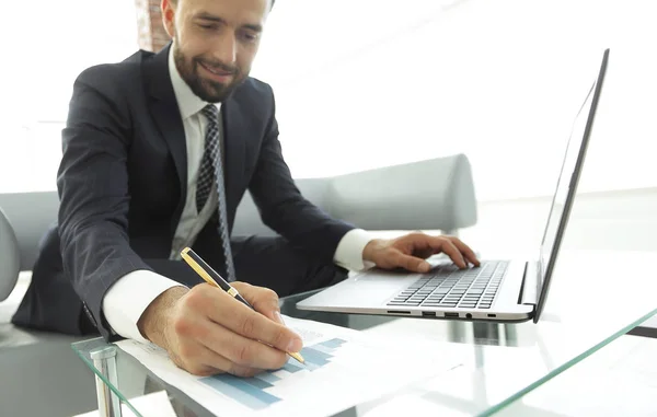 Gerente de finanças trabalhando com gráficos de negócios em um laptop — Fotografia de Stock