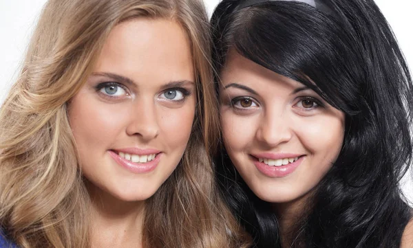 Close-up portrait of two smiling young female friends against wh — Stock Photo, Image