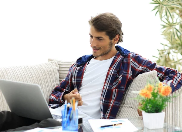 Überraschter junger Mann arbeitet von zu Hause aus mit Laptop. — Stockfoto