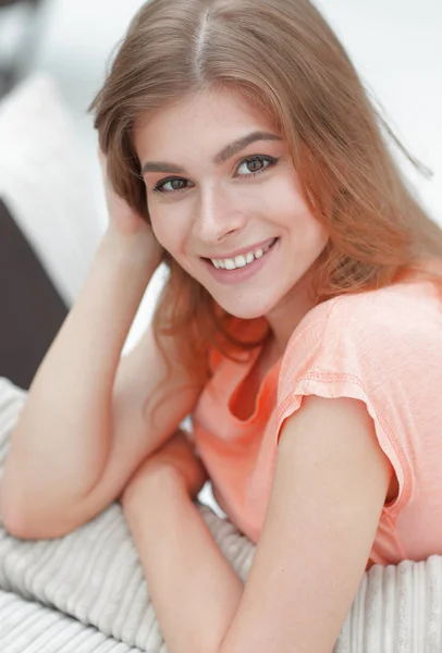 Porträt einer jungen lächelnden Frau im Hintergrund des Wohnzimmers. — Stockfoto