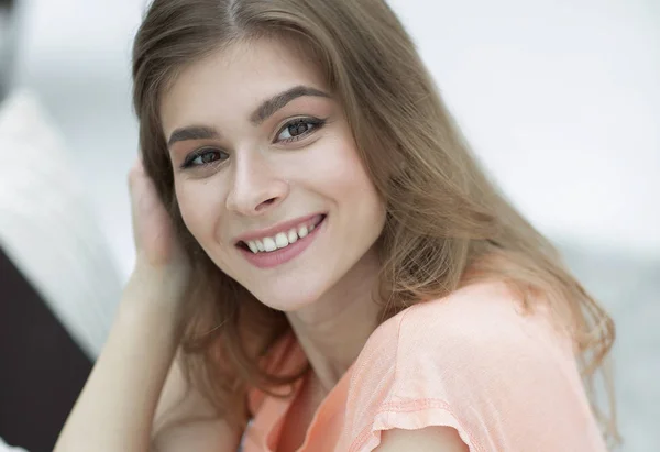 Portret van jonge lachende vrouw op de achtergrond van de woonkamer. — Stockfoto