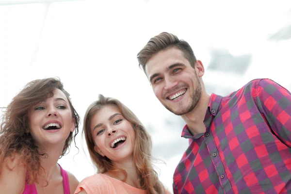 Close-up de três jovens sorrindo em fundo branco — Fotografia de Stock
