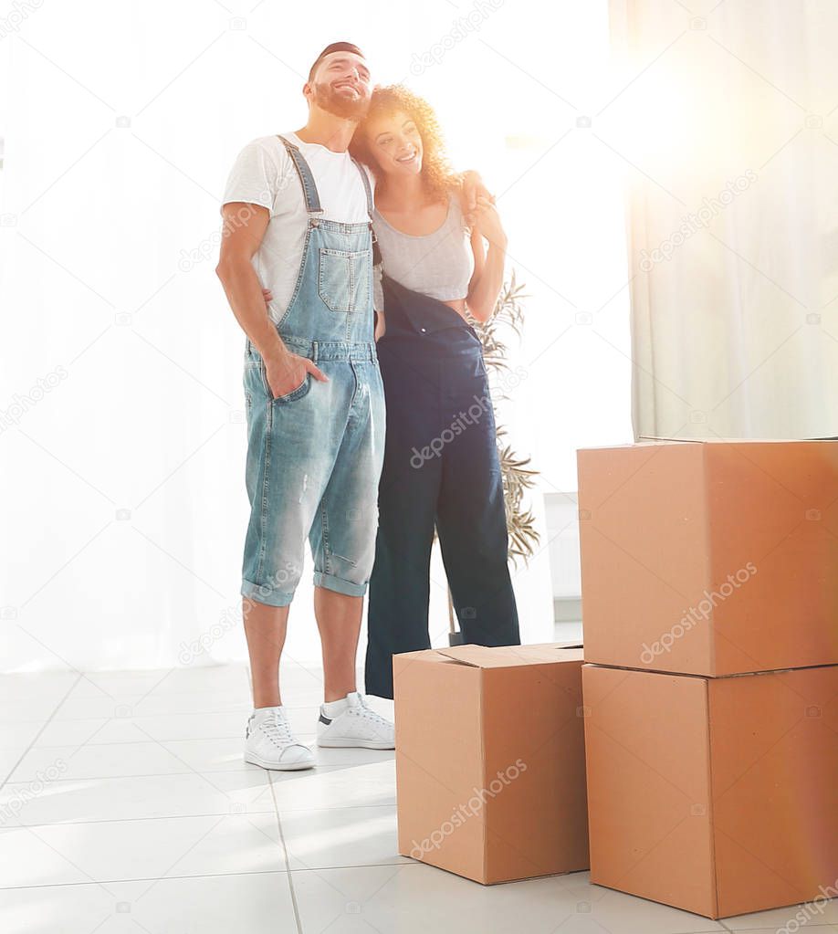 Happy young couple standing in new apartment