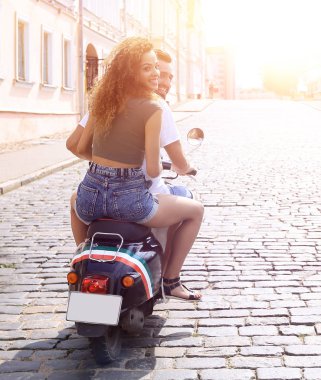mutlu genç bir çift bir scooter üzerinde eğleniyor