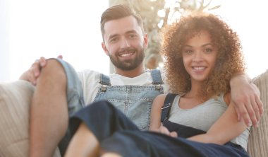 Genç çift kanepede oturan iş elbiseleri