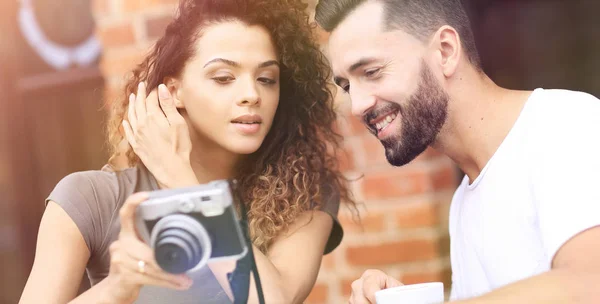 Retrato de una pareja sentada en un café y mirando fotos —  Fotos de Stock