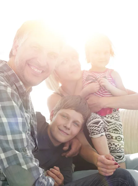 Família com duas crianças sentadas juntas e olhando para a câmera — Fotografia de Stock