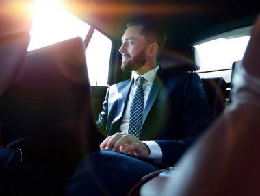 laptop ile çalışan ve bir araba pencereden dışarı bakarak işadamı