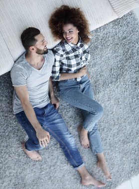 gülümseyen iki yeni bir daire içinde bir halı üzerinde yalan