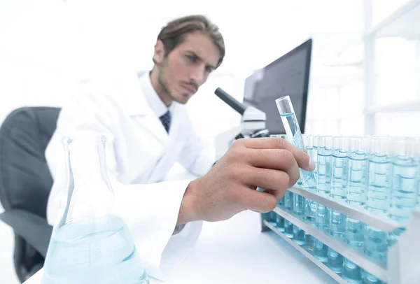 Químico mirando tubos de ensayo con líquidos azules —  Fotos de Stock
