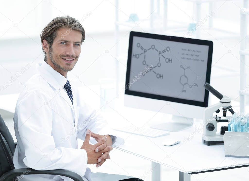 Portrait of a male scientist with a monitor looking at the camer