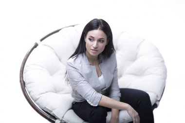 Genç kadın bir yuvarlak rahat yumuşak büyük sandalyede oturuyor.