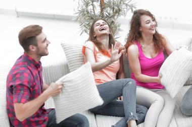 neşeli arkadaşları kanepede oturan yastık ile oynarken