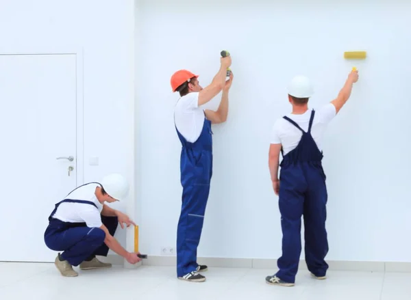 Команда строителей отделочных работ работает в помещениях — стоковое фото