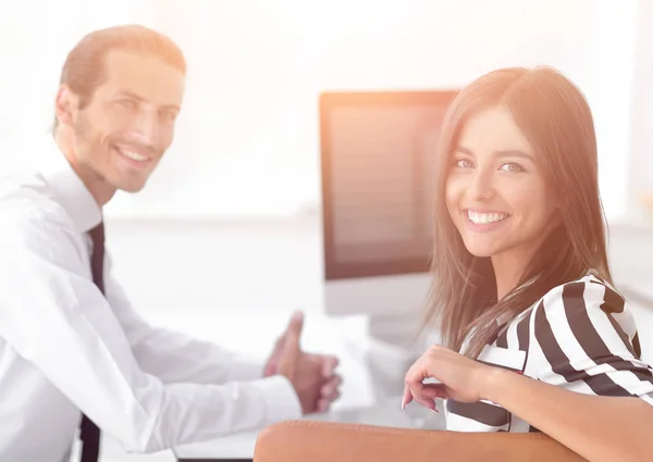 Deux jeunes employés assis derrière un bureau — Photo