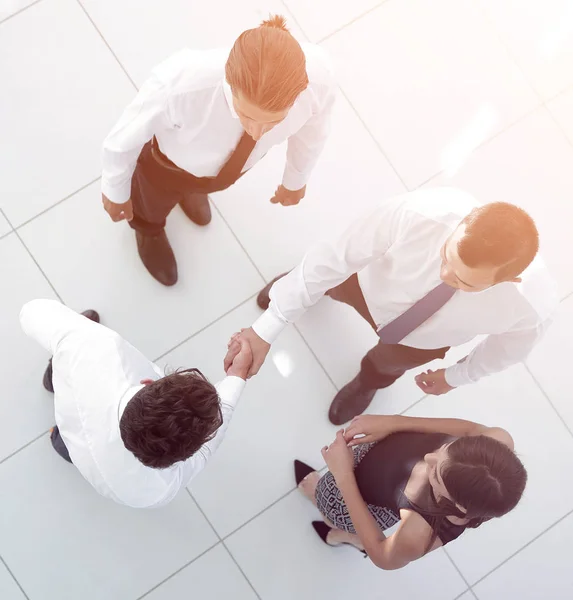 View from the top. colleagues shaking hands in office lobby. — Stock Photo, Image