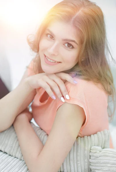 Portret van jonge lachende vrouw op de achtergrond van de woonkamer. — Stockfoto