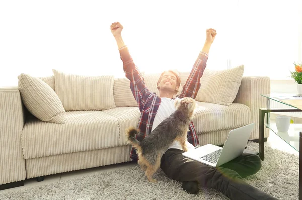 Cara feliz com seu cão sentado em uma espaçosa sala de estar — Fotografia de Stock