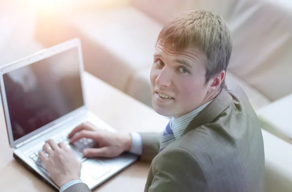 Bovenaanzicht van een jonge man in pak pak die op laptop werkt — Stockfoto