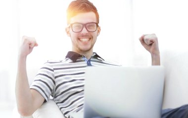 mutlu adam kanepede oturan dizüstü bilgisayar ile