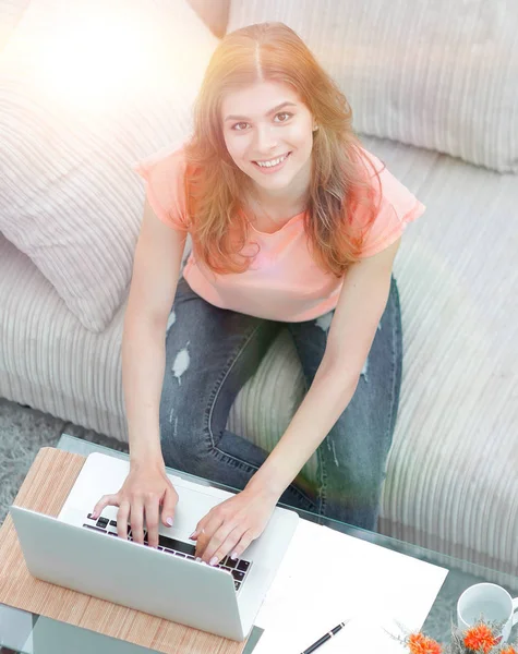Meisje student werkt aan laptop terwijl u zit in de buurt van een koffietafel — Stockfoto