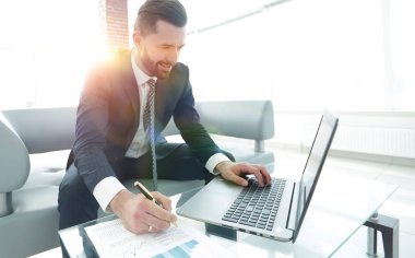 Dizüstü bilgisayarda çalışan ve Notlar not defterinde yapma şık adam