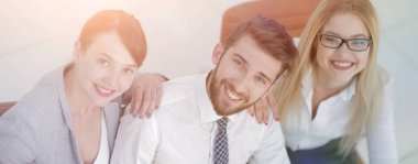 masada oturan ve kameraya bakarak başarılı iş takım.