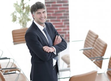 Bir boş toplantı odasında duran iş adamı