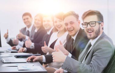 iş takım masasında otururken başparmak yukarıya ile