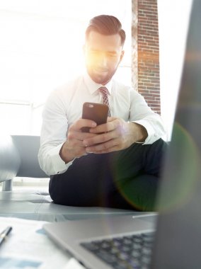 Ekran smartphone önünde oturan bakarak işadamı bir 