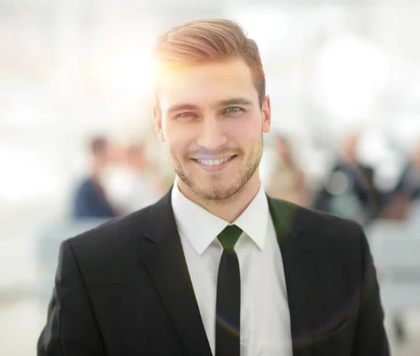 Porträt eines selbstbewussten jungen Geschäftsmannes vor verschwommenem Hintergrund. — Stockfoto