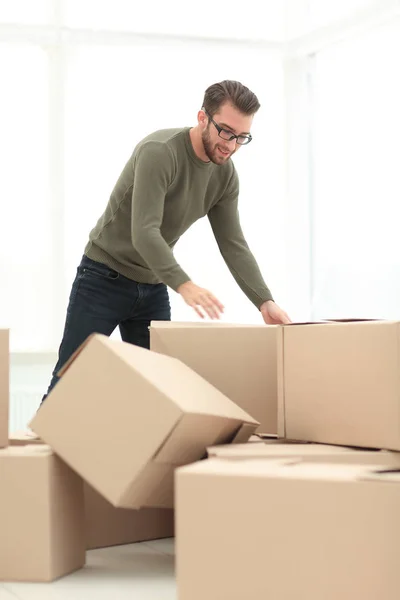 Homem confiante desempacotar caixas na nova casa — Fotografia de Stock