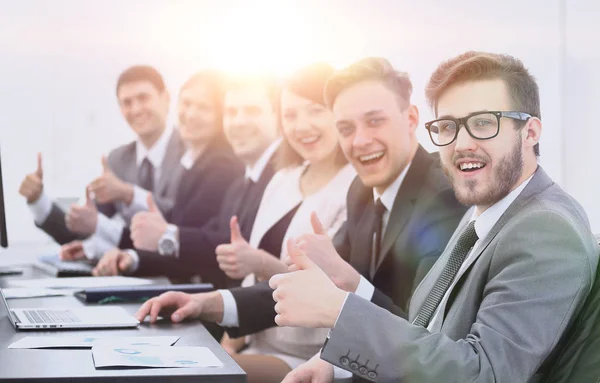 Business team met duimen omhoog zittend op zijn Bureau — Stockfoto