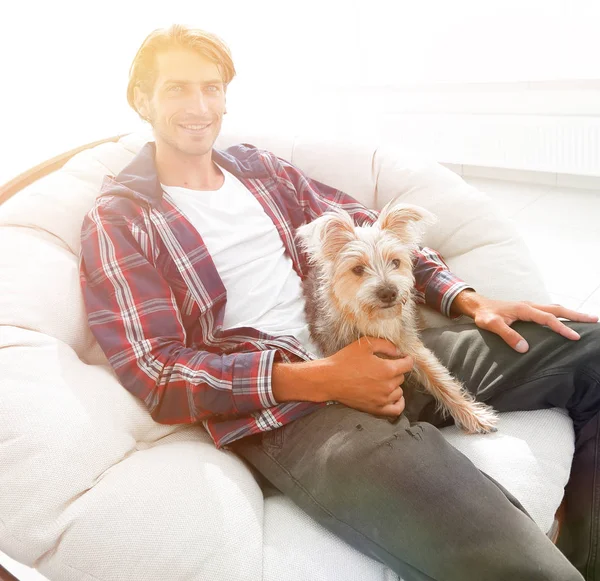 Stylish guy sitting in a large comfortable armchair. — Stock Photo, Image