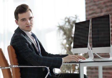 bir masanın arkasında ofiste çalışan