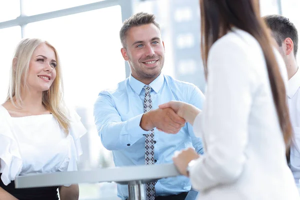 Fechar. Gerente aperta a mão de uma cliente mulher . — Fotografia de Stock