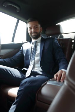 bir arabanın arka koltuğunda oturan işadamı