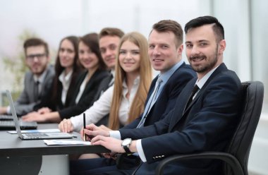 İş ekibi konferans odasındaki masada oturuyor.