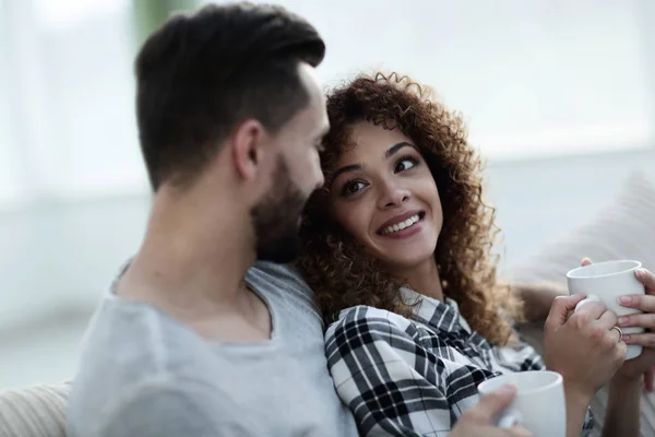 Verliefde paar zittend op een bank in de woonkamer — Stockfoto