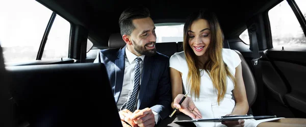 Uomo e donna che discutono documenti di lavoro in taxi — Foto Stock