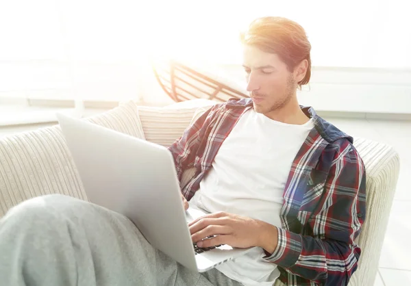 Ernsthafter junger Mann mit Laptop. — Stockfoto