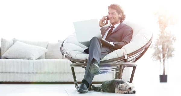 Άνθρωπος των επιχειρήσεων μιλώντας σε ένα smartphone που κάθεται στο σαλόνι — Φωτογραφία Αρχείου